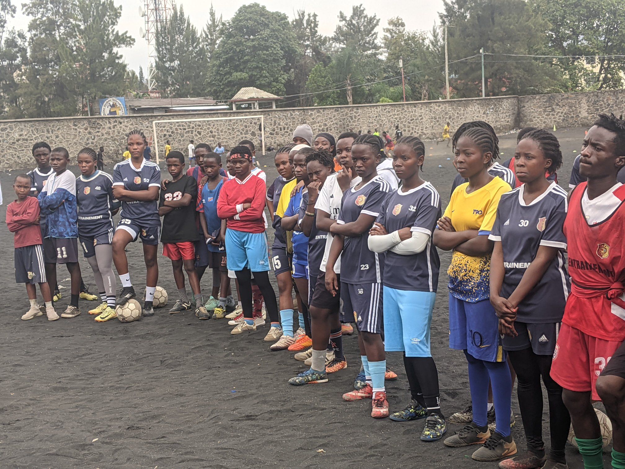 Joueuses alignées sur un terrain de cendre à Goma, photo publiée le 18 septembre 2026 par la page Coach Salama Miruho officiel.