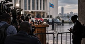 Caméras et micros devant un palais officiel à Kinshasa, drapeau congolais. Photo TIC-TAC HEBDO générée par intelligence artificielle — illustration, pas un reportage.