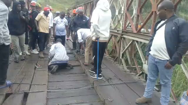 Pont de Kihira à Sake : tablier en bois endommagé, habitants et agents sur l’ouvrage. Photo reçue de Sake, 7 octobre 2026.